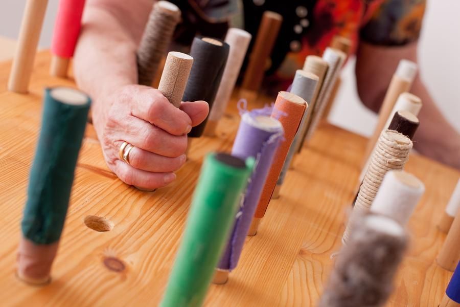 Hirnleistungstraining durch gezieltes Greifen nach verschiedenen Griffen befestigt auf einem Holzbrett