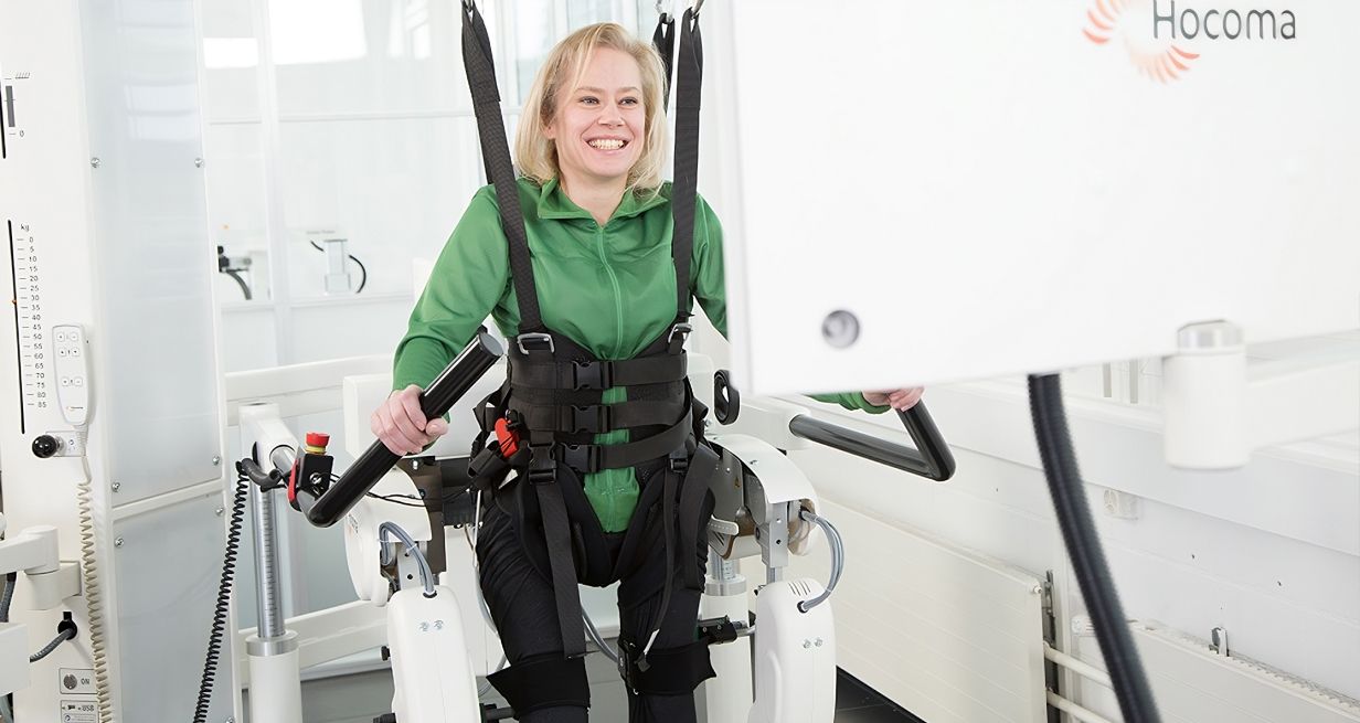 Frau nutzt ein Gerät mit Roboterunterstützung zur Therapie