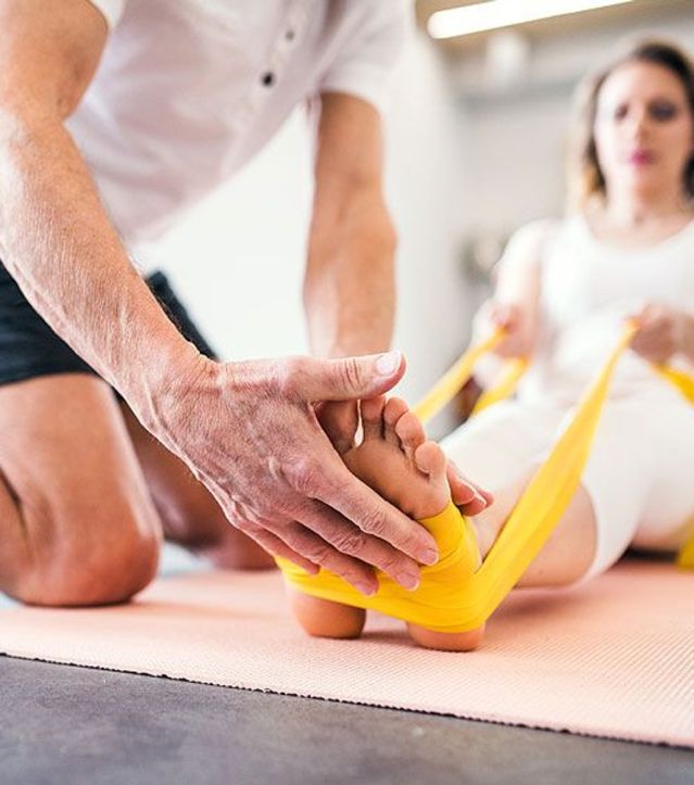 Therapeut unterstützt eine Patientin bei einer Ergotherapie